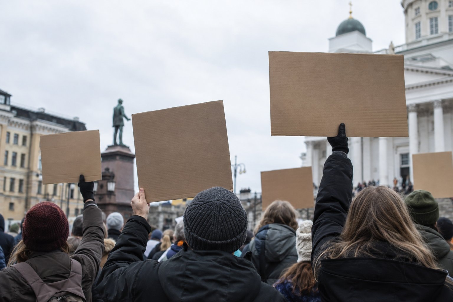 Kansalaisjoukko tyhjine kyltteineen pohjoismaisella aukiolla